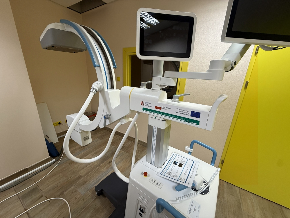 Nowoczesny aparat RTG na mobilnym ramieniu C, wykorzystywany do diagnostyki obrazowej w szpitalu, umożliwiający precyzyjne badania radiologiczne podczas zabiegów medycznych.